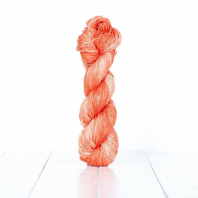 1220, a coral skein of Urth Yarn's hand-dyed Monokrom Cotton DK weight yarn.