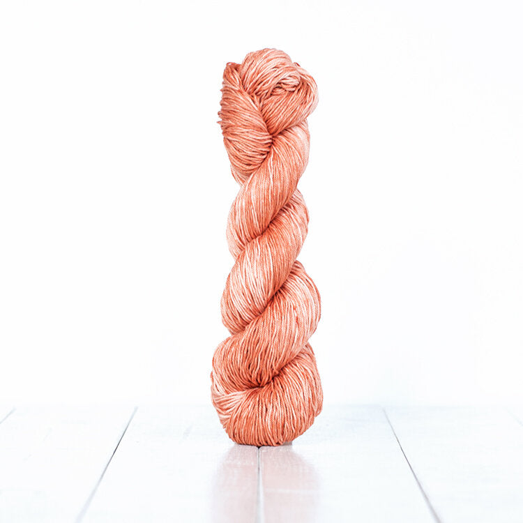 1222, a dusty coral skein of Urth Yarn's hand-dyed Monokrom Cotton DK weight yarn.