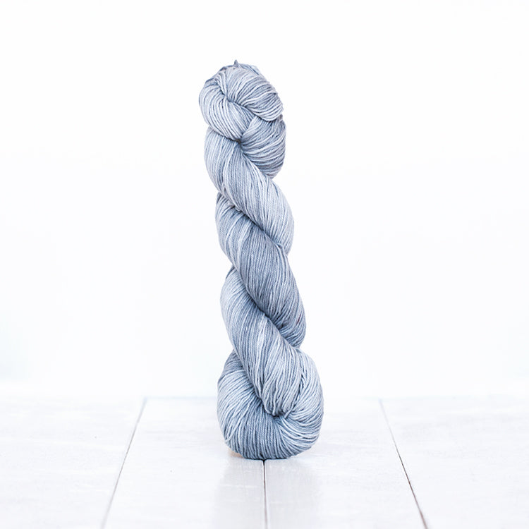 1223, a cool-toned silvery grey skein of Urth Yarn's hand-dyed Monokrom Cotton DK weight yarn.
