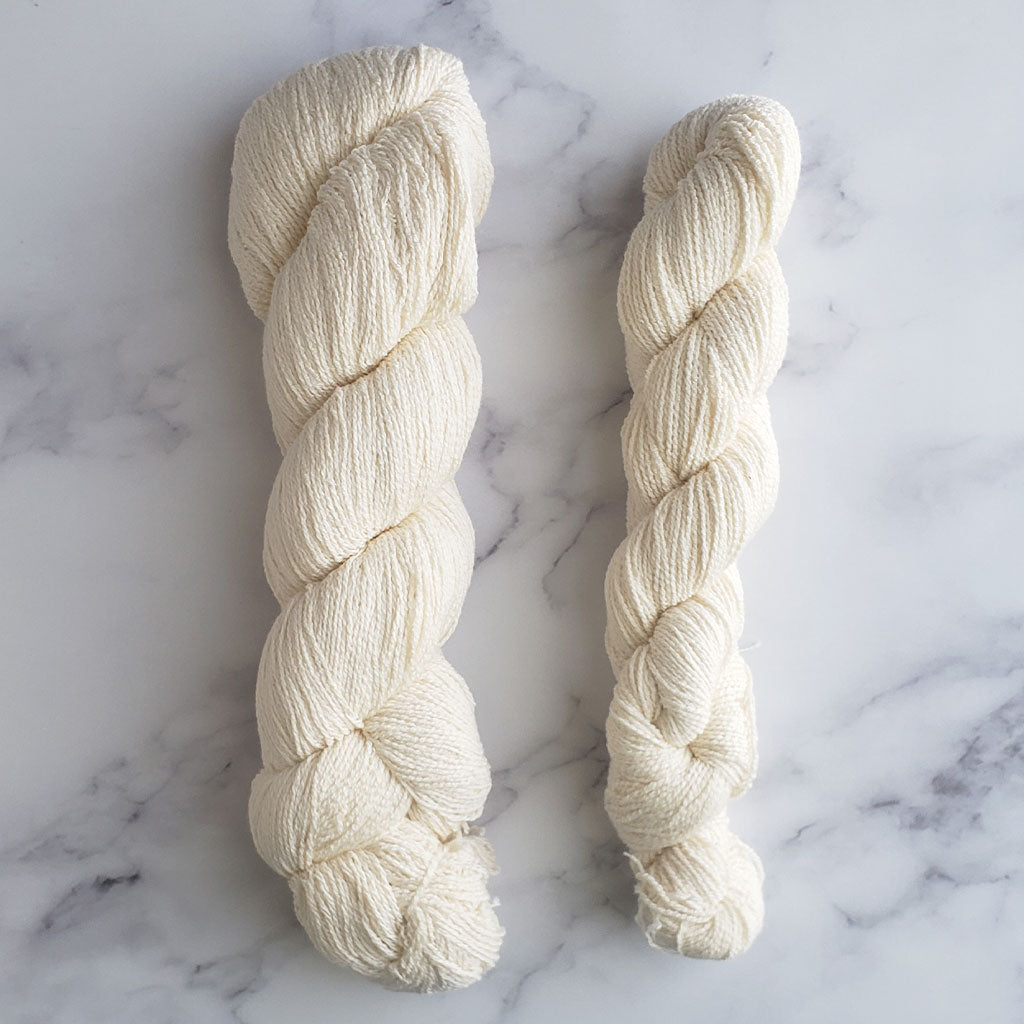 Undyed CoBaSi sock / fingering yarn shown in 100 and 5 gram skeins.