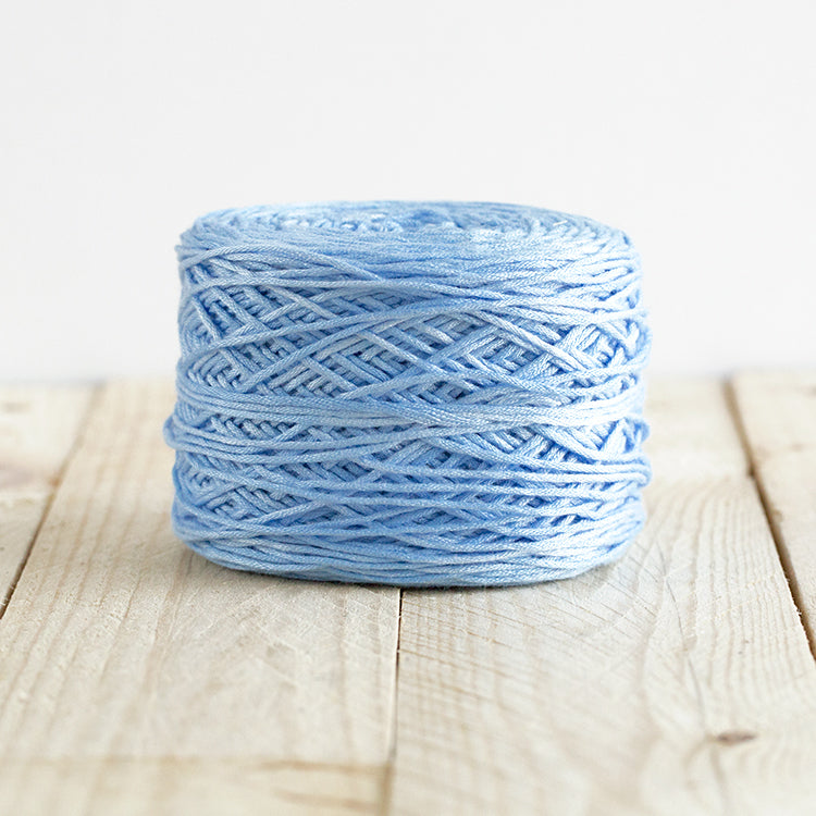 Color 5001, an light cornflower blue cake of yarn.