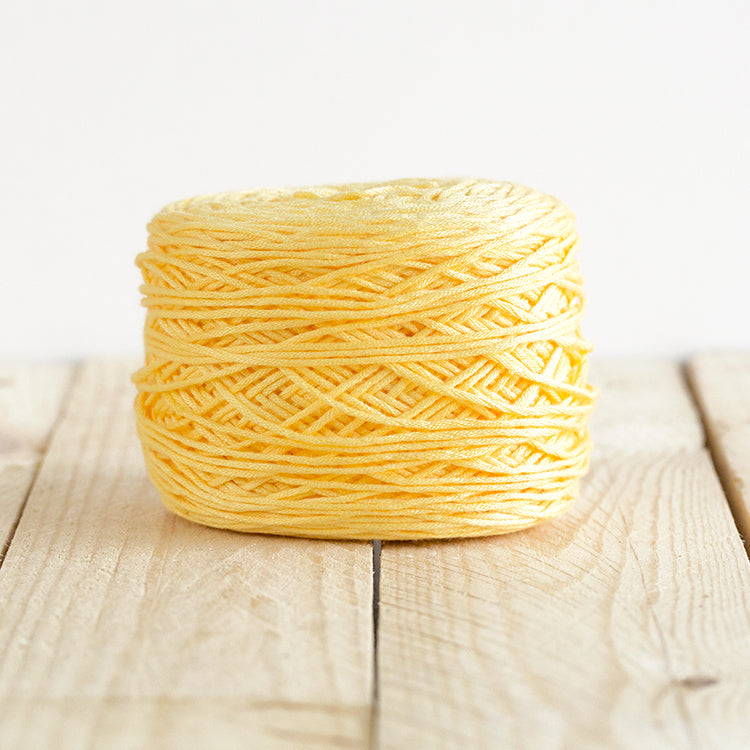 Color 5002, a warm yellow cake of yarn.