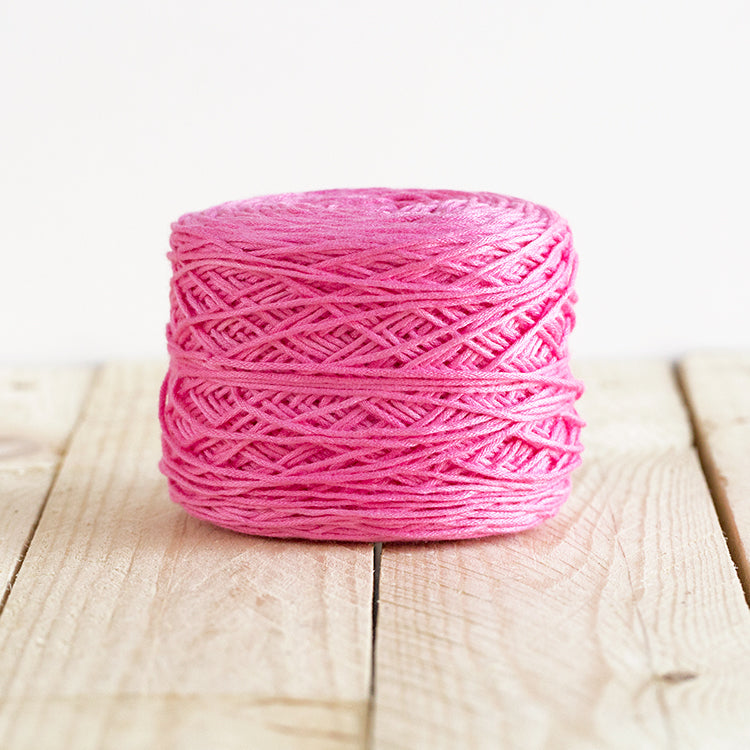 Color 5003, a bright bubble gum pink cake of yarn.