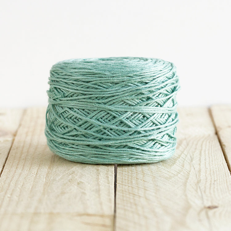 Color 5012, a light seafoam green cake of yarn.