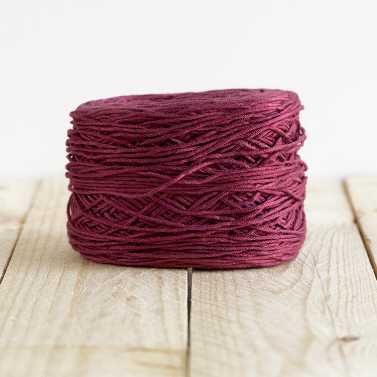 Color 5013, a wine colored burgundy cake of yarn.