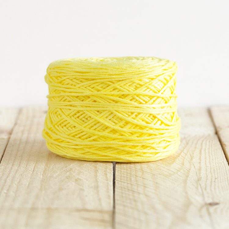 Color 5016, a bright lemon yellow cake of yarn.