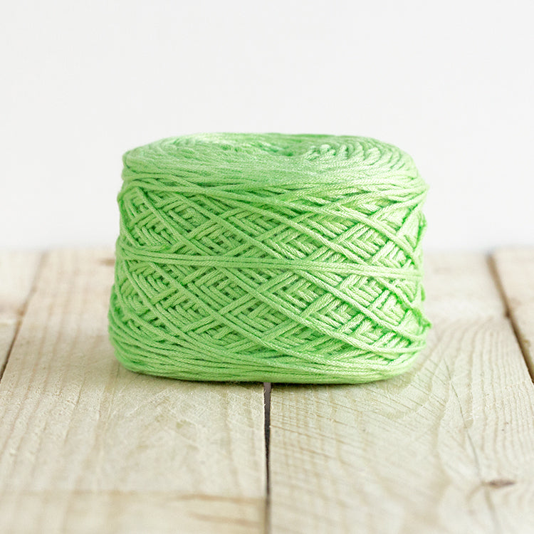 Color 5020, a light, bright, lime green cake of yarn.
