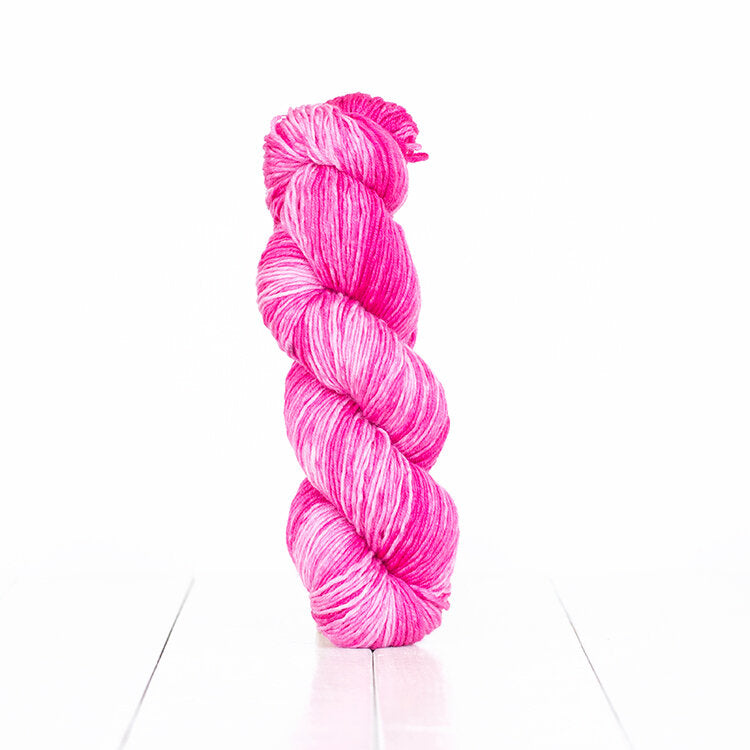 Color 6066, a variegated monochromatic skein of yarn in bright vibrant pink.