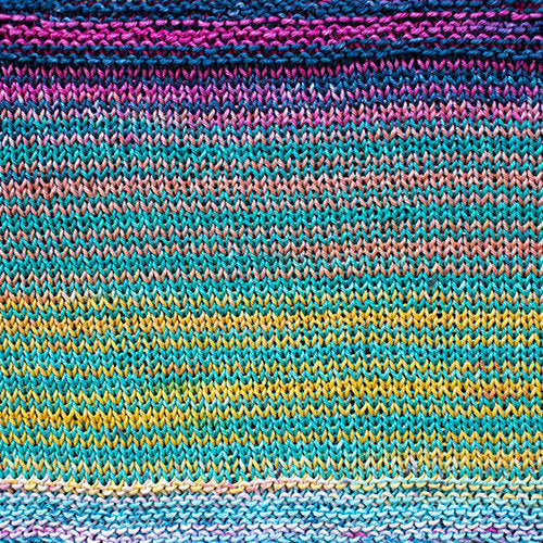 A swatch of Uneek Cotton in the colorway 1089, stripes in shades of blues, pinks, & bright yellow. 