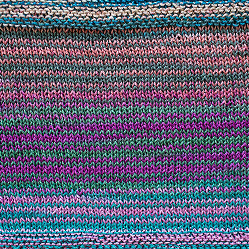 A swatch of Uneek Cotton in the colorway 1093, stripes of purple, blue, green, pink, & grey.