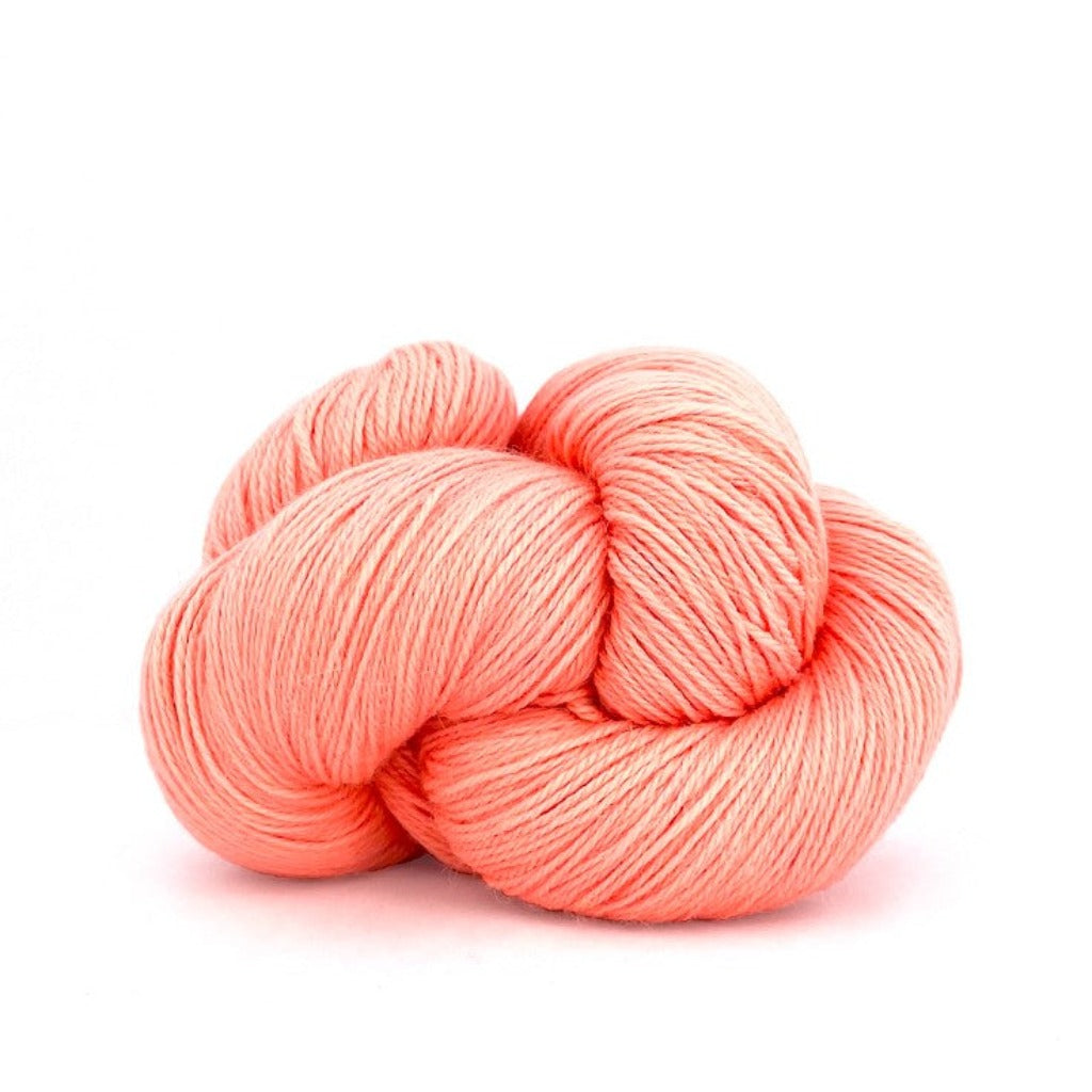 Cantaloupe 865: A twisted hank of Kelbourne Woolens Perennial Fingering yarn in peachy pink color