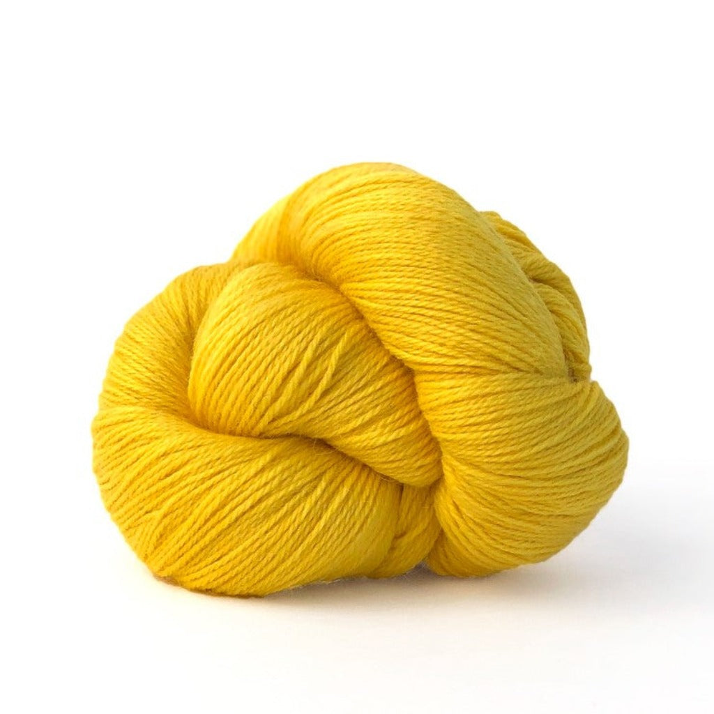 Pineapple 735:A twisted hank of Kelbourne Woolens Perennial Fingering yarn in pineapple yellow color
