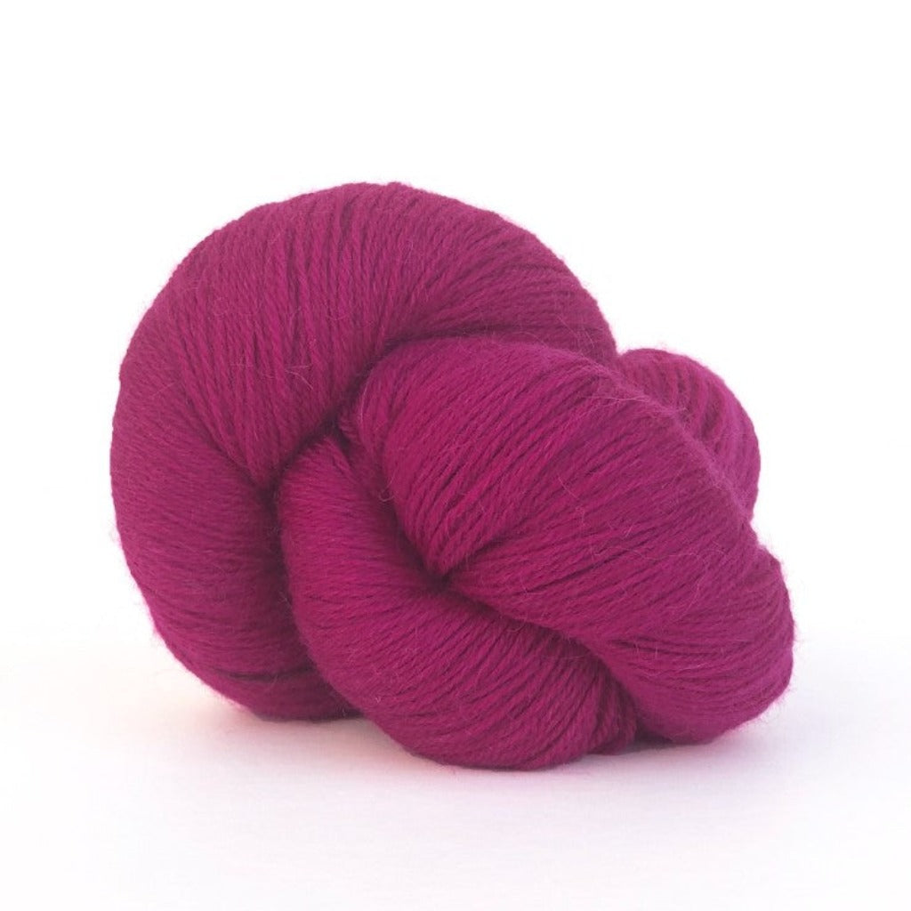 Raspberry 520: A twisted hank of Kelbourne Woolens Perennial Fingering yarn in a raspberry red color