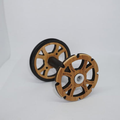 Majacraft Stylus bobbin at an angle, bamboo flange with black fibreglass barrel