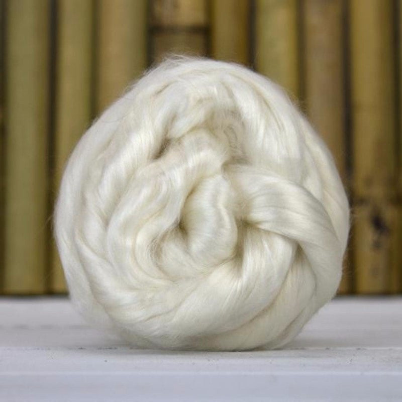 A ball of white undyed rose spinning fiber top.