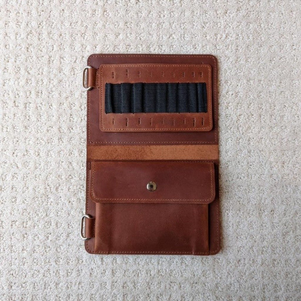 Whiskey brown leather knitting case open to show black elastic tabs to hold needles 