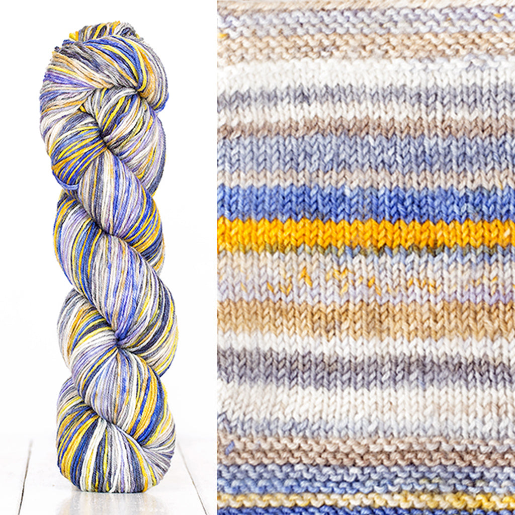 Color 3016: a hand-dyed skein of self striping wool yarn with white, grey, tan, blue, and yellow shades