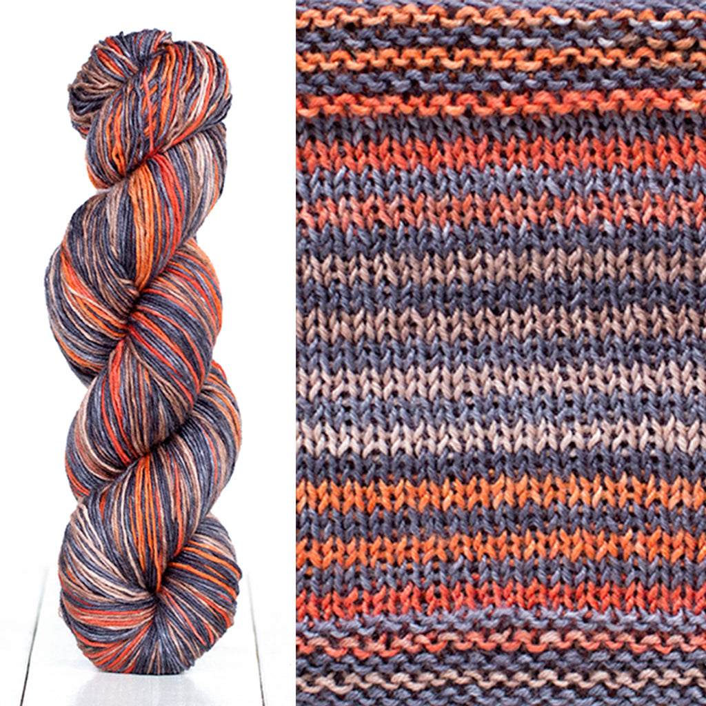 Color 3021: a hand-dyed skein of self striping wool yarn with blue, orange, grey, and white shades