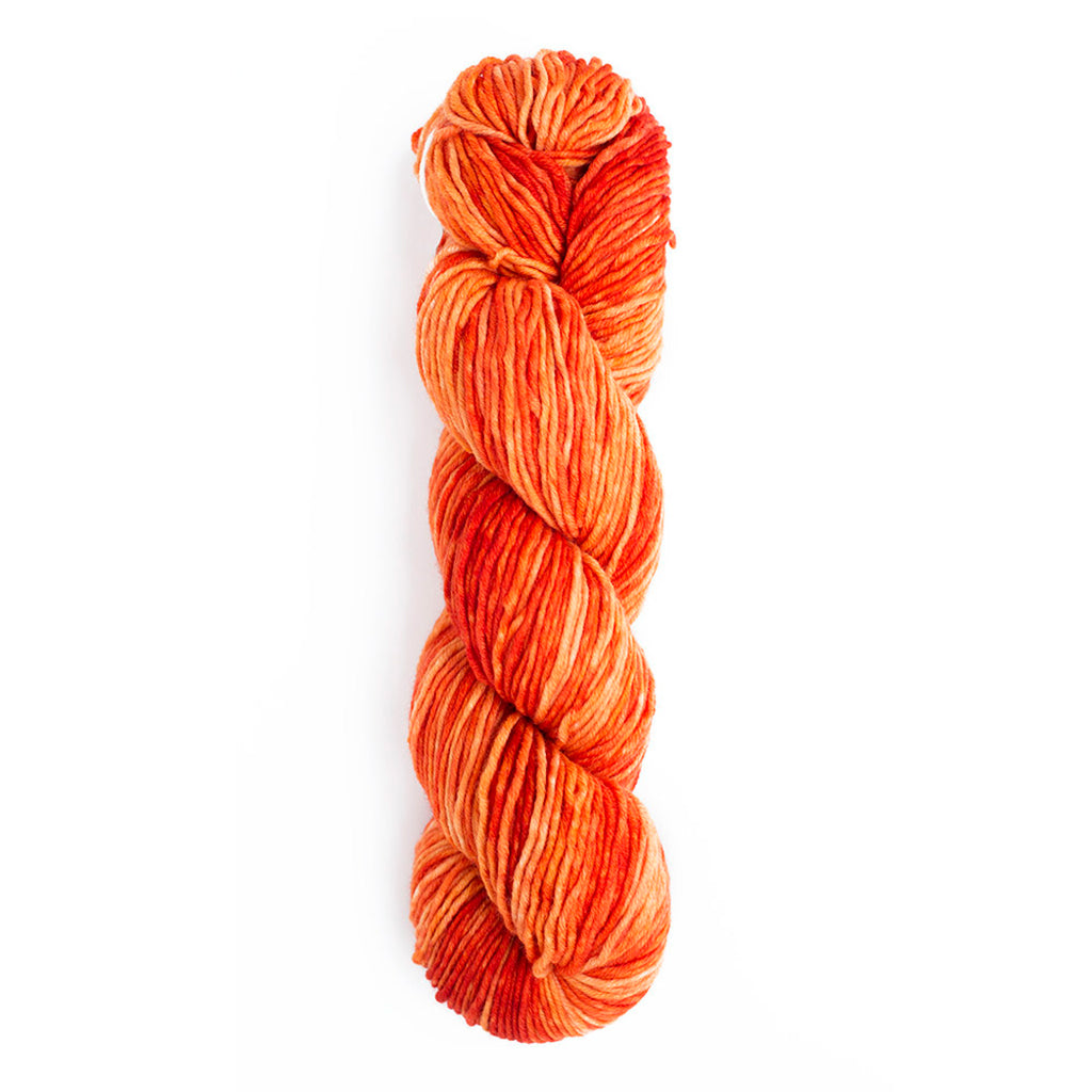 A skein of Monokrom Worsted, color 4052 which is a tonal citrusy orange.