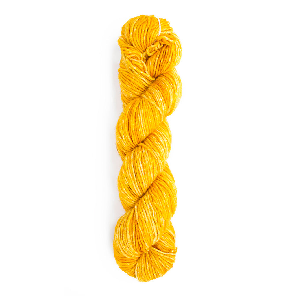 A skein of Monokrom Worsted in color 4053 which is a bright tonal yellow reminiscent of a sunny day.