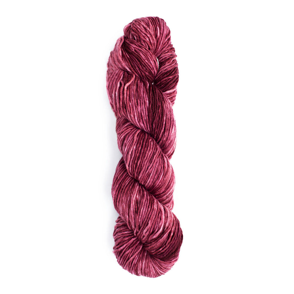 A skein of Monokrom Worsted, color 4054 which is a lovely rich tonal Cabernet wine color.