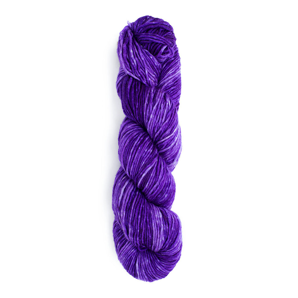 A skein of Monokrom Worsted, color 4055, which is a deep, vibrant, tonal purple.