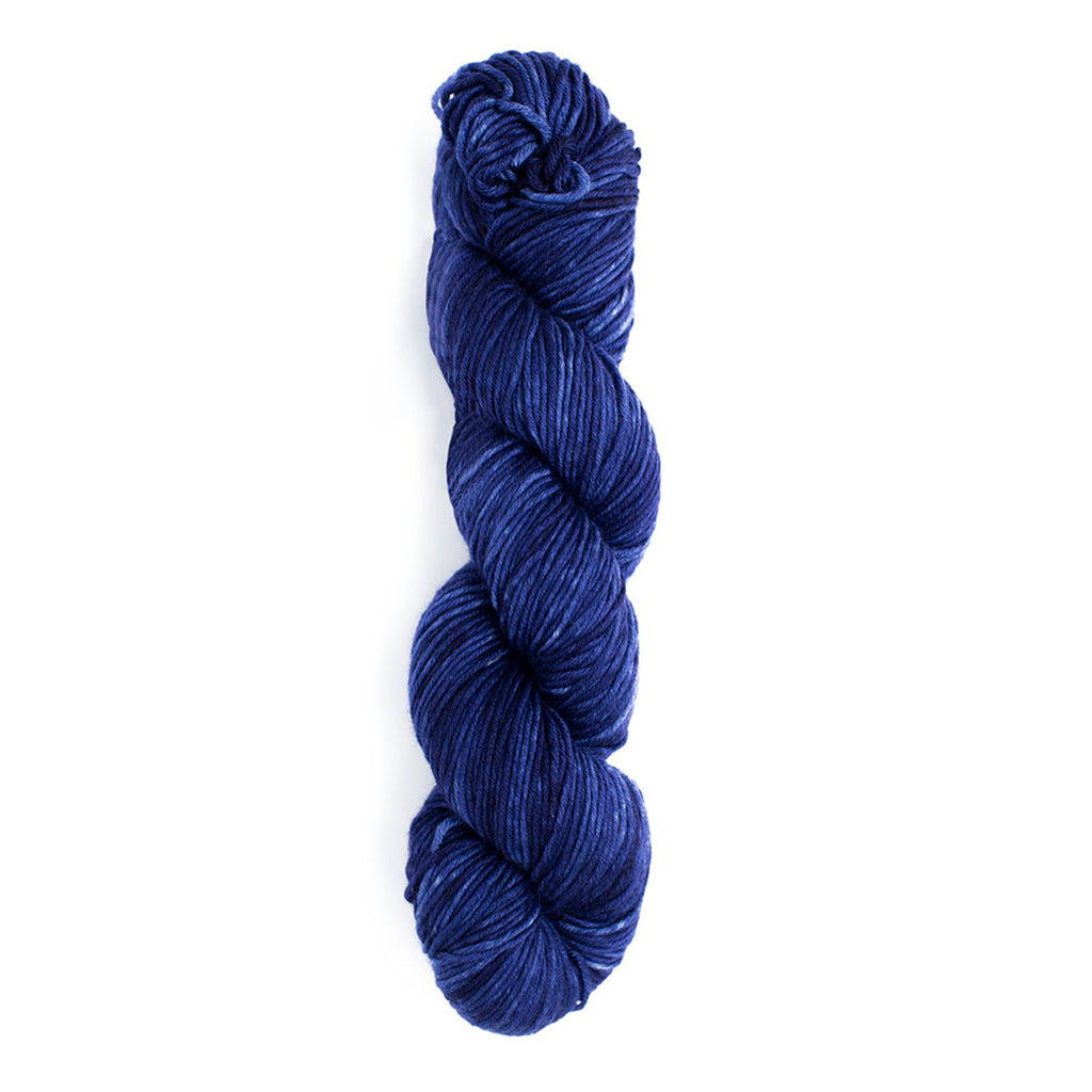 A skein of Monokrom Worsted, color 4056, a dark tonal blue reminiscent of the night sky.