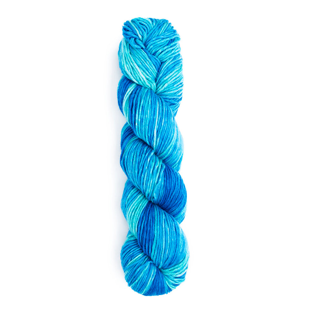 A twisted hank of Monokrom Worsted in the color 4057, monochromatic shades of a bright cyan blue.