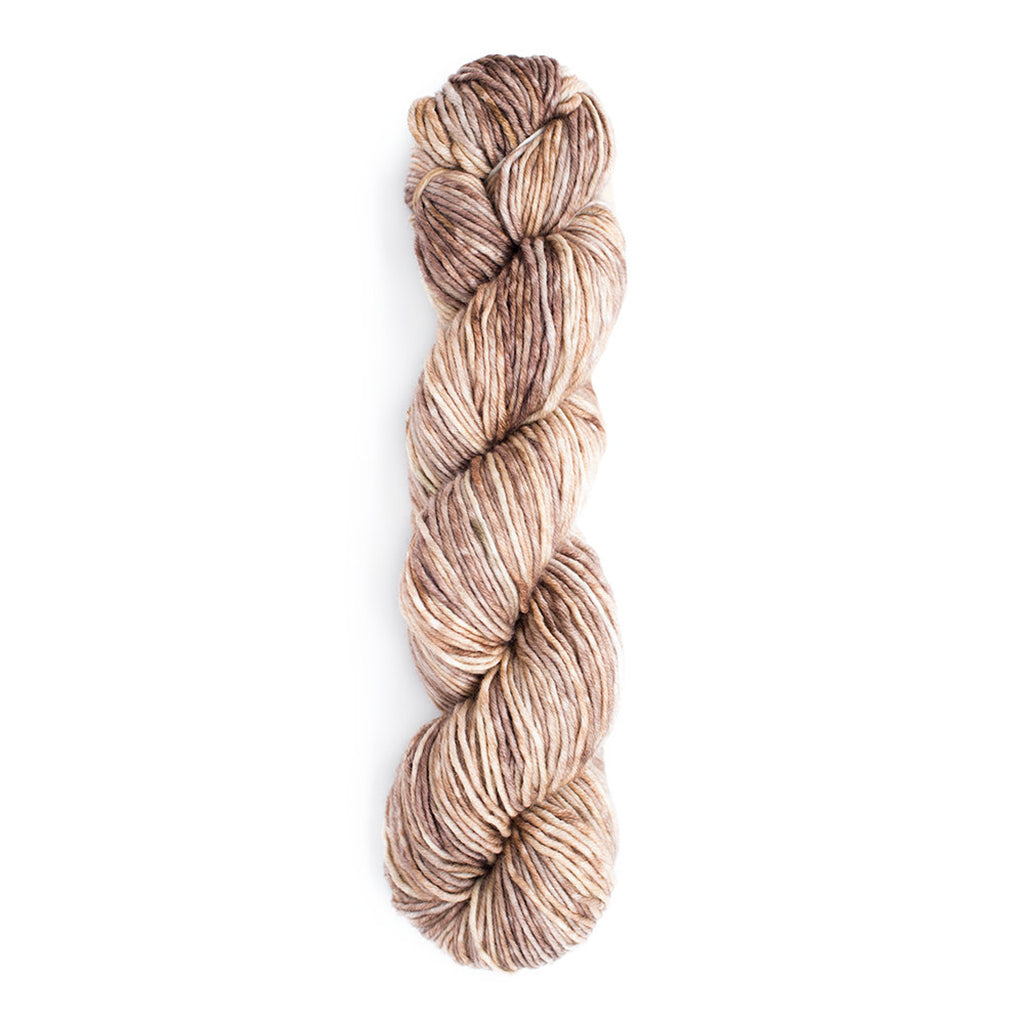 A skein of Monokrom Worsted, color 4062, a light tonal brown the color of a warm sandy beach.