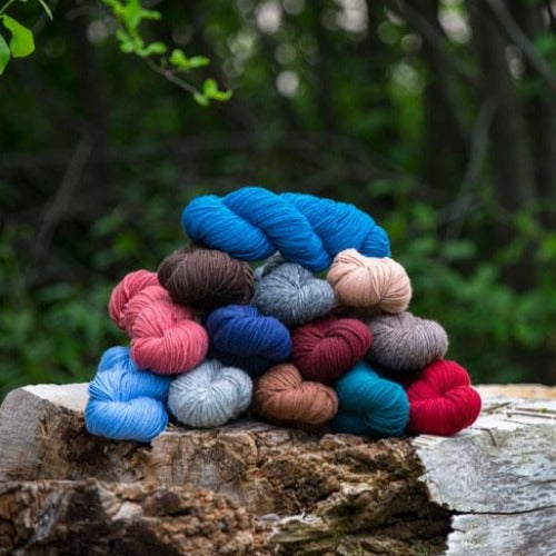 A pile of various colors of Brown Sheep Top of The Lamb Sport Yarn