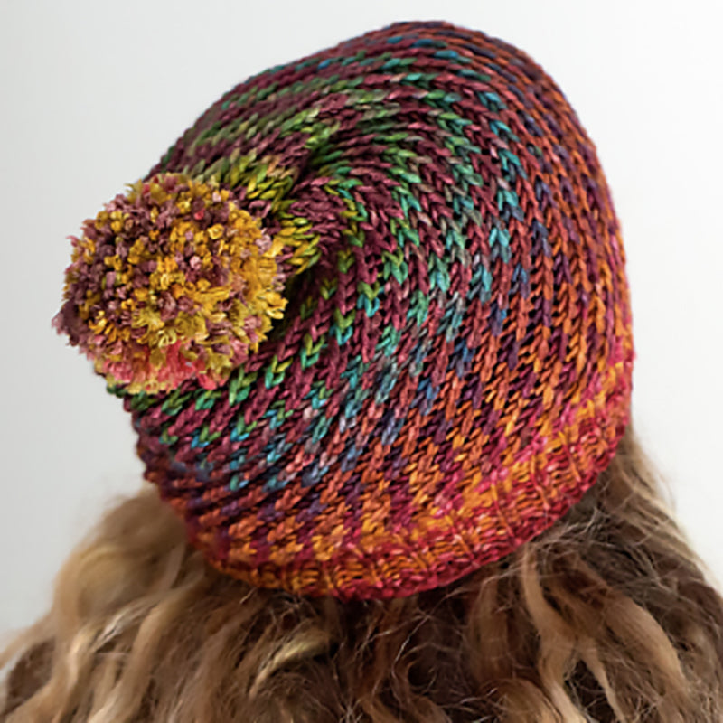 A colorful Flux Hat hand-knit in Urth Yarns Uneek Worsted.