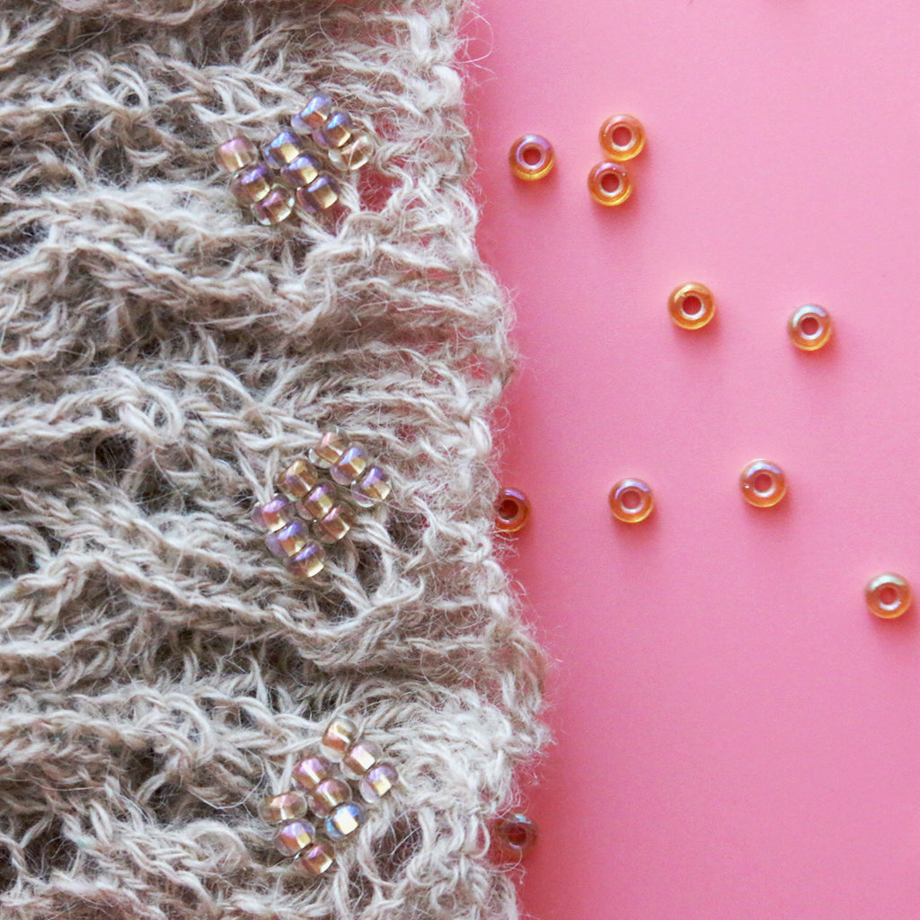 A close up look at Miyuki seed beads strung onto a handknit cowl.