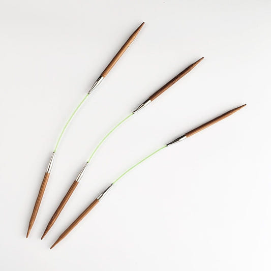 Three HiyaHiya 8 inch bamboo flyers, each with two bamboo tips joined by a green flexible cord