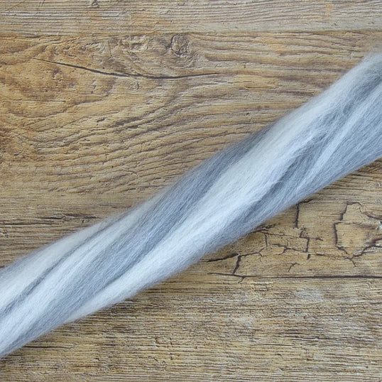 A strand of tonal humbug merino wool top in the shades natural and grey.