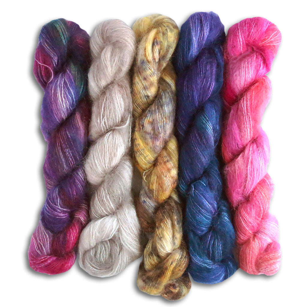 Five twisted hanks of Malabrigo mohair yarn in laying next to each other in a line. 