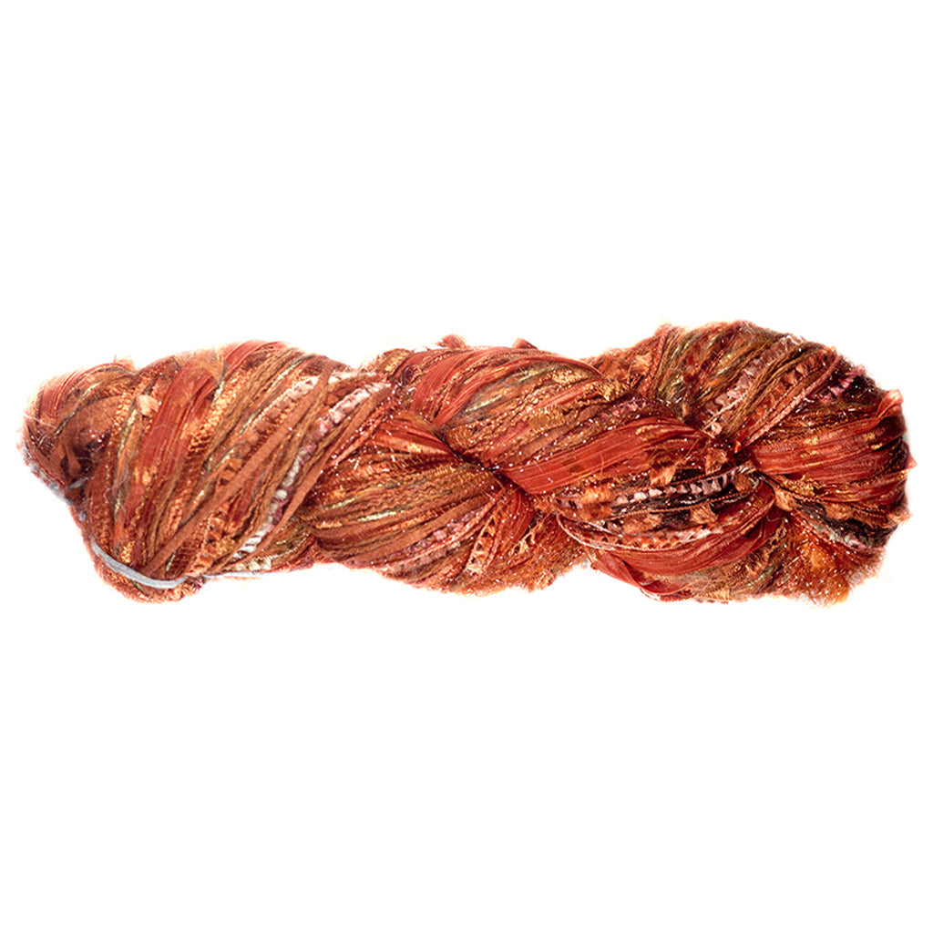 Color 521, a skein of rusty orange yarn, full of texture and sparkle.