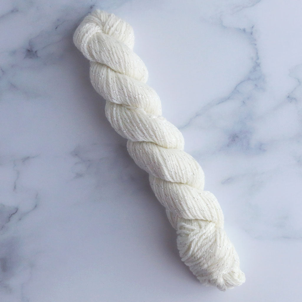 A single mini skein of stardust, a superwash merino nylon with silver lurex sock yarn.