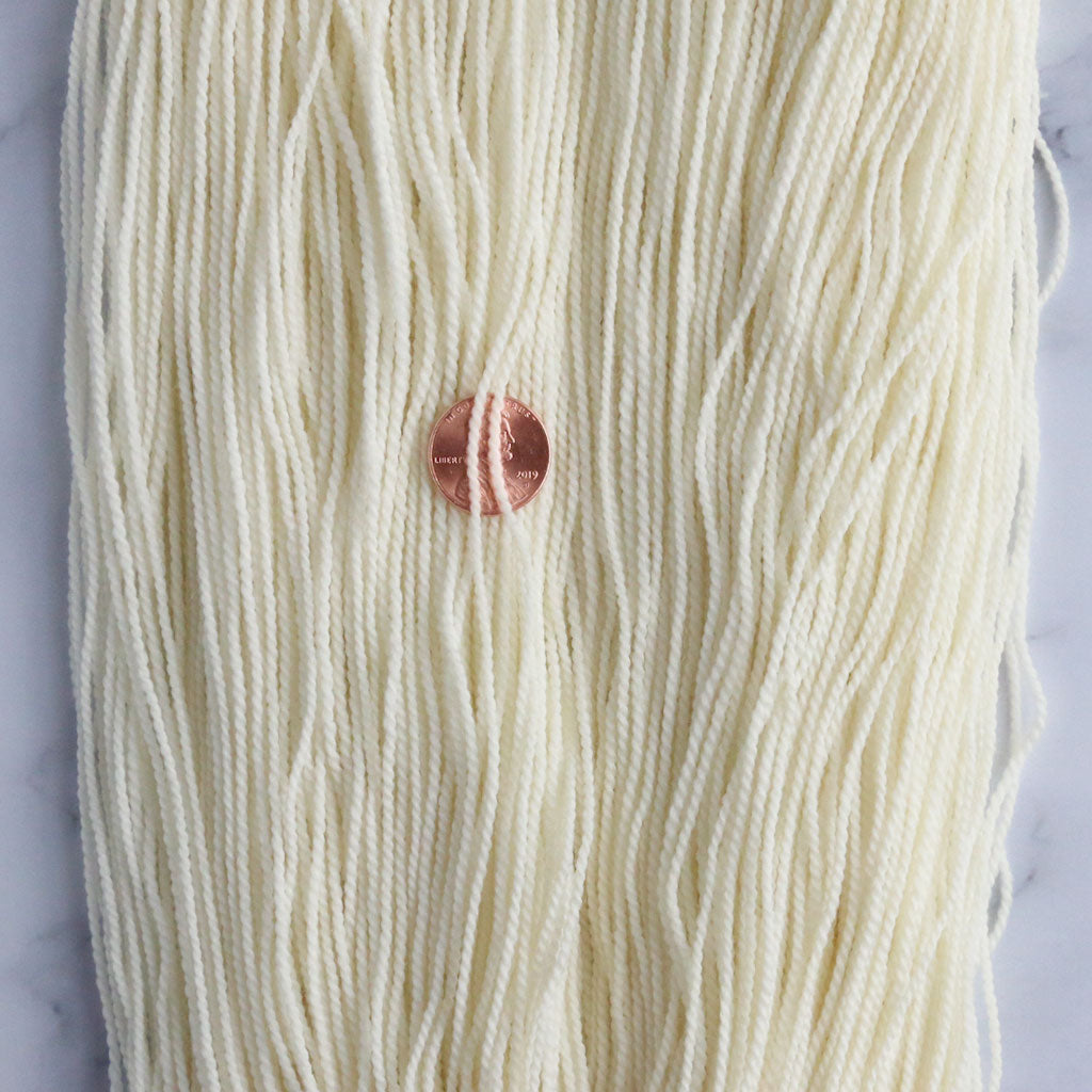 Close up of one skein of undyed high twist sock yarn