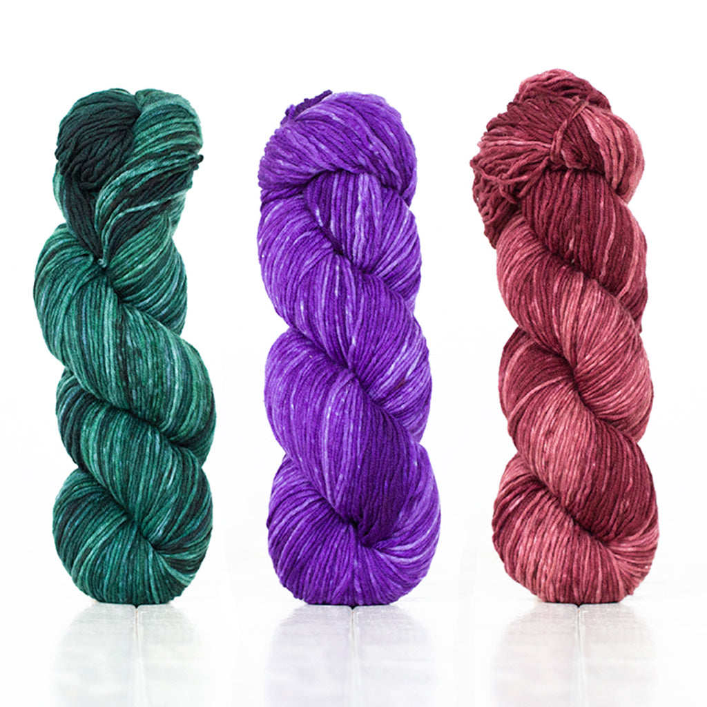 3 skeins of Monokrom DK showcasing the rich depth of color this hand-dyed yarn line has.