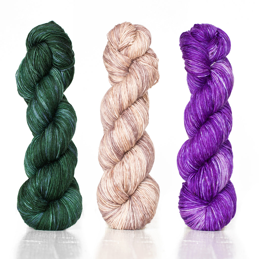 3 skeins of Monokrom Fingering showcasing the rich depth of color this hand-dyed yarn line has.