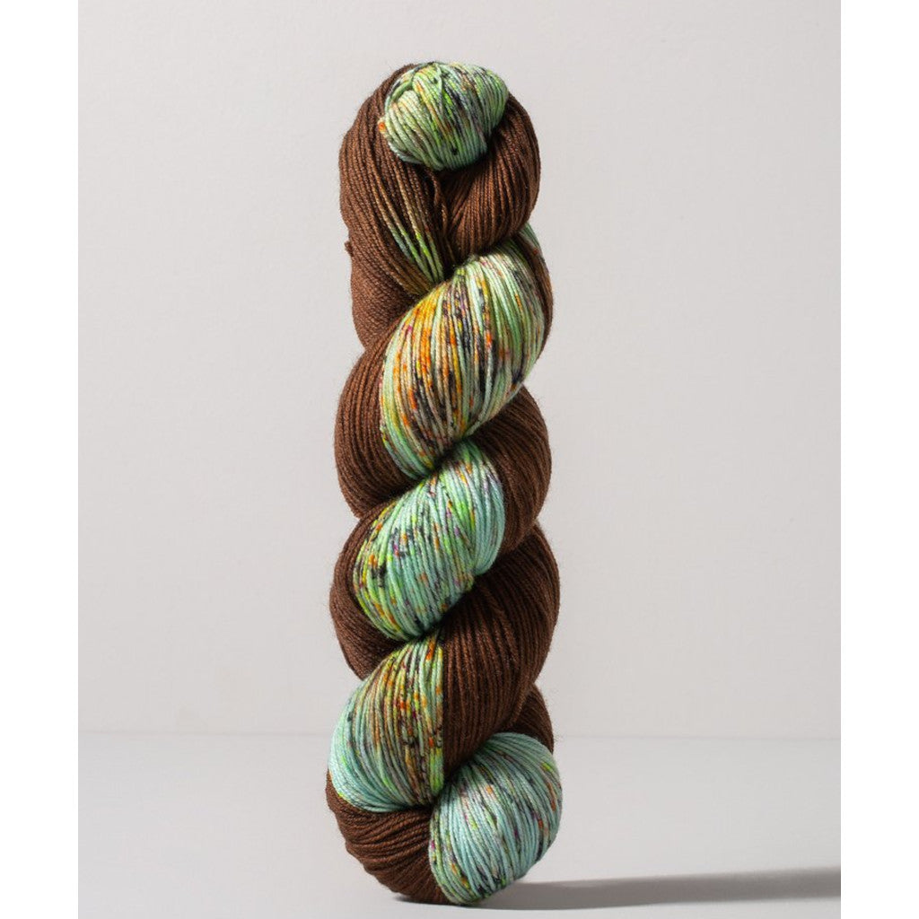 Gusto Carmen Fingering 1406 - a brown colorway with speckled cool blue, mint green, yellow and blue 