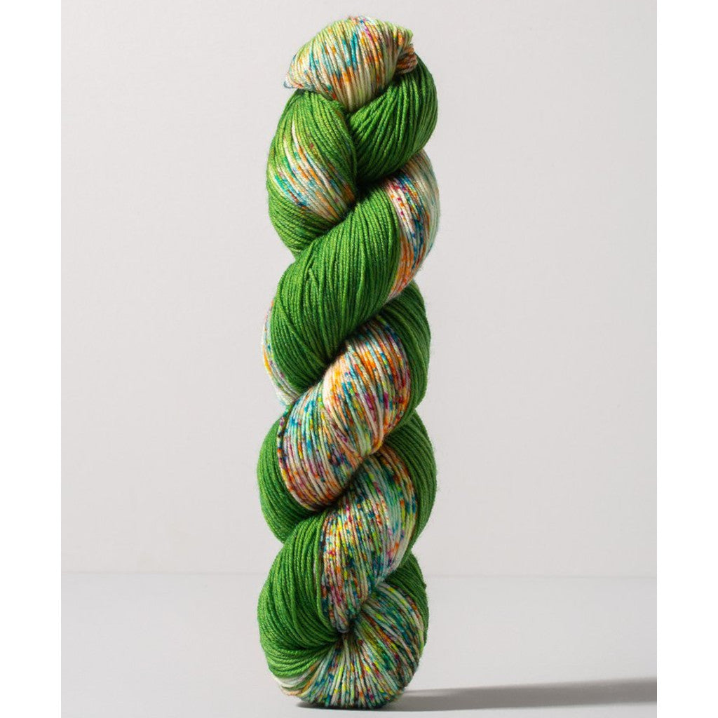 Gusto Carmen Fingering 1408 - a grass green colorway with speckled white, yellow, blue and magenta 