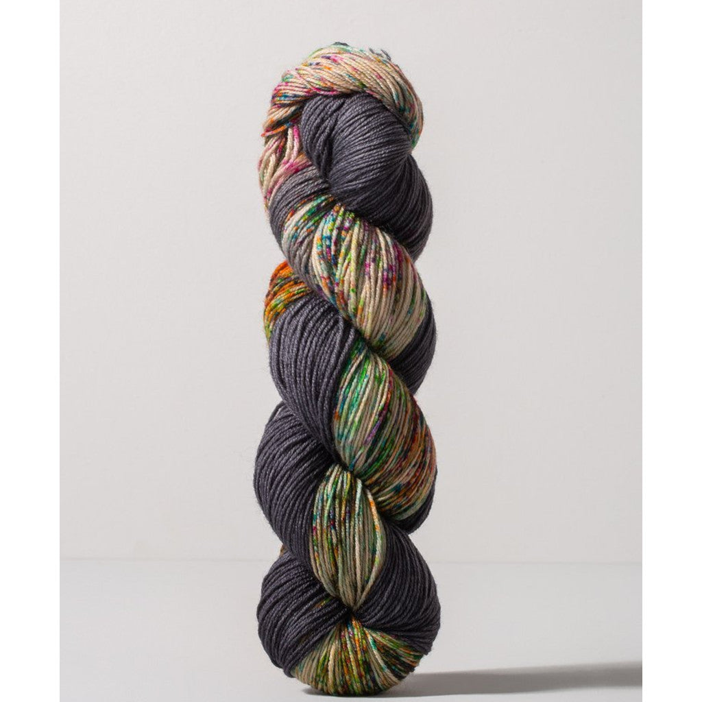 Gusto Wool Carmen Fingering 1410 - a dark grey colorway with speckled tan, green, yellow and magenta