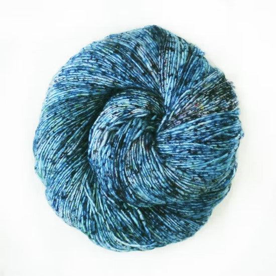 Malabrigo Mechita Lago Yarn - a light blue yarn with green speckles