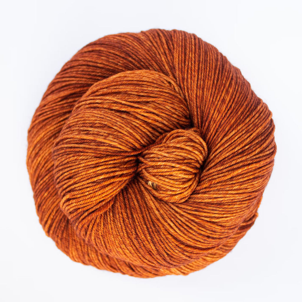 Color: Caramel 142 . A golden caramel variegated skein of Malabrigo Ultimate Sock yarn