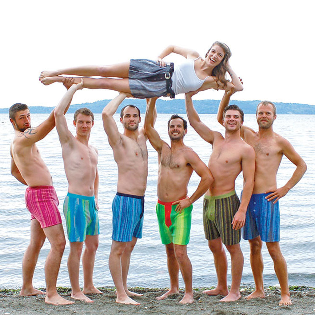 6 men wearing Socks Appeal Knitted Shorts while holding 1 woman also wearing the shorts. 