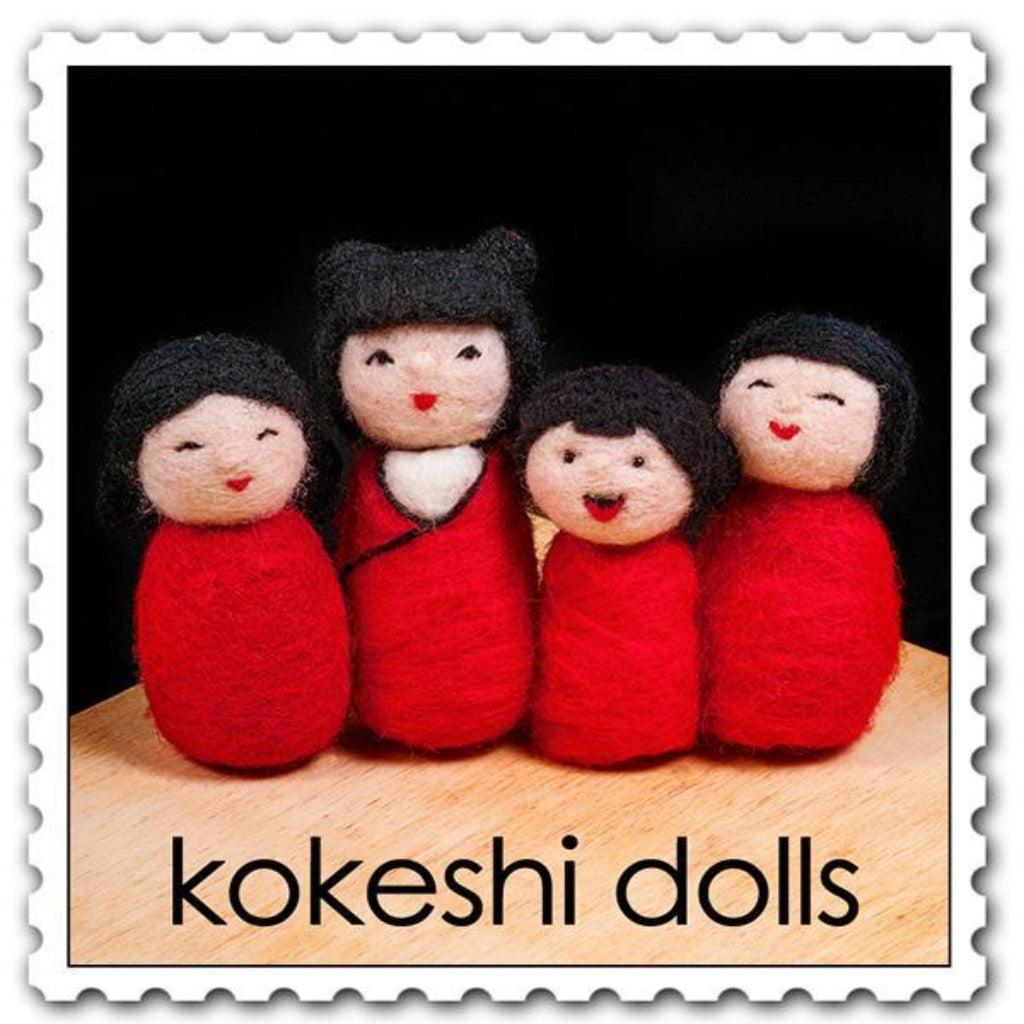 Woolpets kokeshi dolls needle felting kit - a set of four smiling dolls all wearing a red wrap with black hair