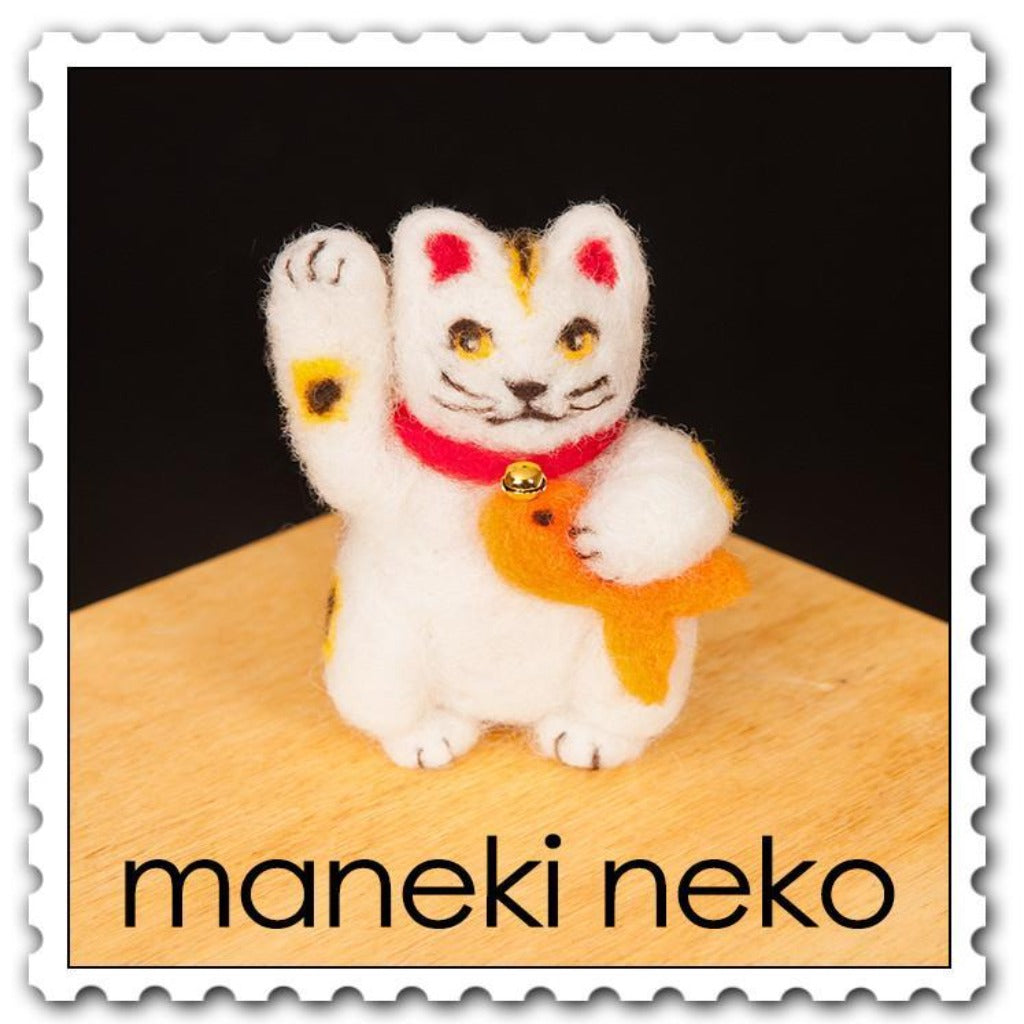 Woolpets maneki neko needle felting kit - a white waving cat holding a yellow goldfish and wearing a red collar with a gold bell 