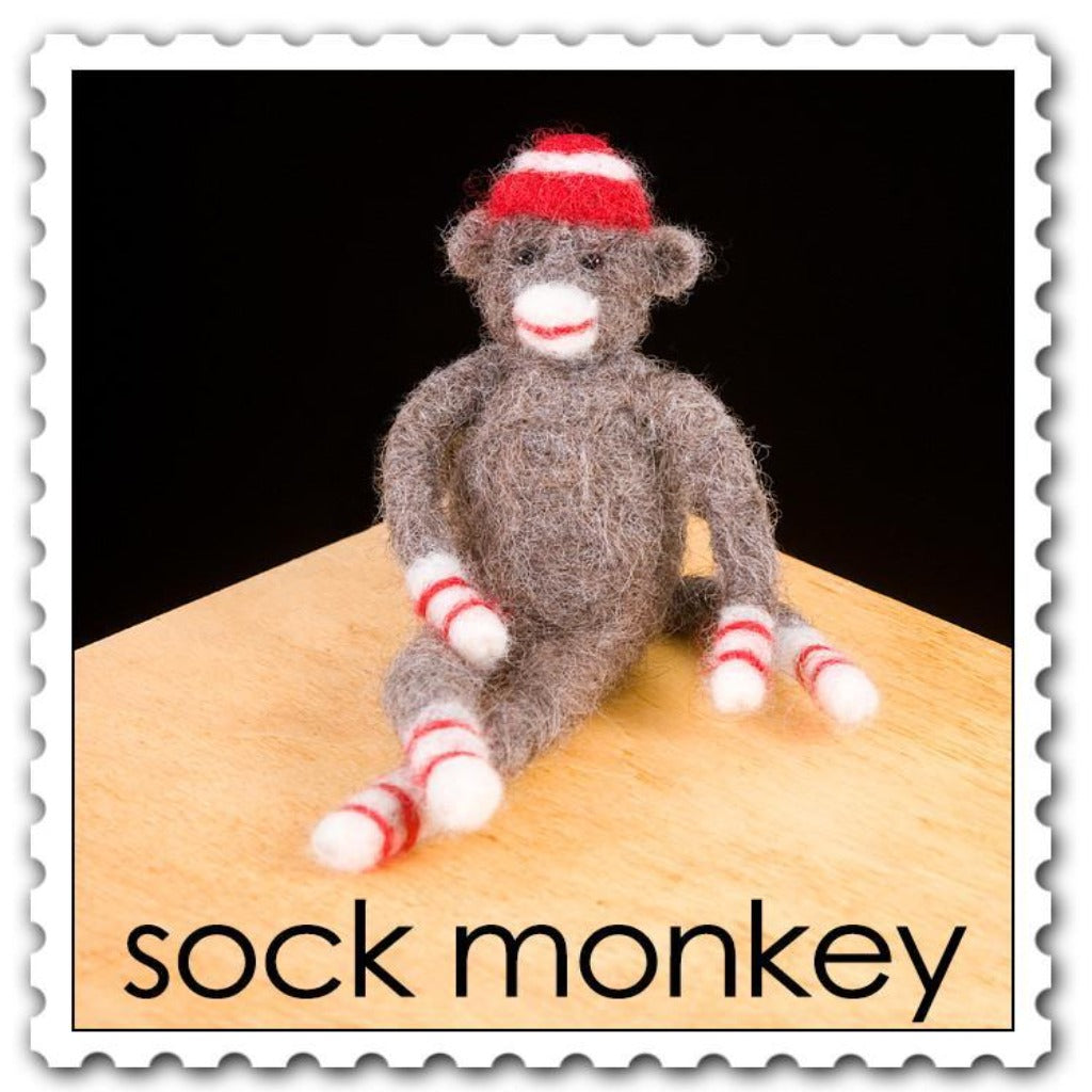 Woolpets sock monkey needle felting kit - a brown and tan sock monkey with white paws with two red stripes and a red and white striped hat 